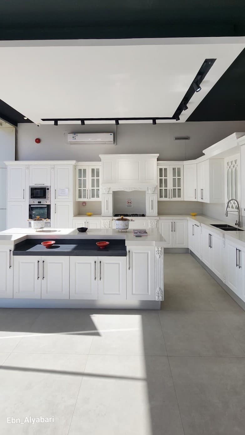 White classic kitchen with framed doors, glass cabinets and an island — built by Blum for Kitchens
